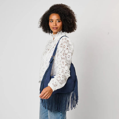 Moda Luxe Reba Hobo navy suede fringe bag worn crossbody, side view, white lace blouse