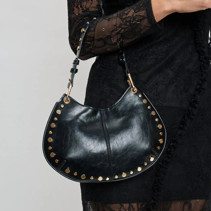 Close-up of black studded leather crescent shoulder bag with gold hardware detail