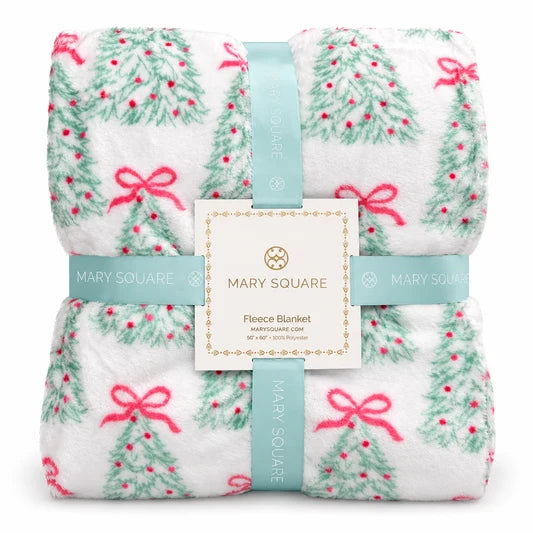 White fleece blanket with green Christmas trees and pink bows, rolled and banded