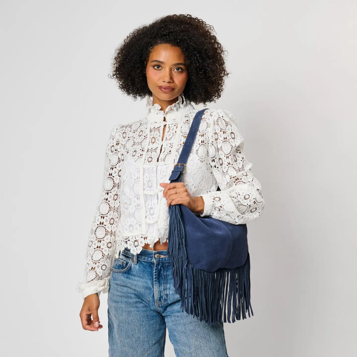Moda Luxe Reba Hobo navy suede fringe bag on shoulder, front view, white lace blouse and jeans