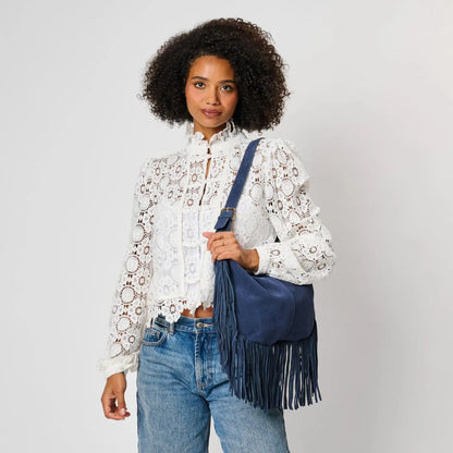 Moda Luxe Reba Hobo navy suede fringe bag on shoulder, front view, white lace blouse and jeans