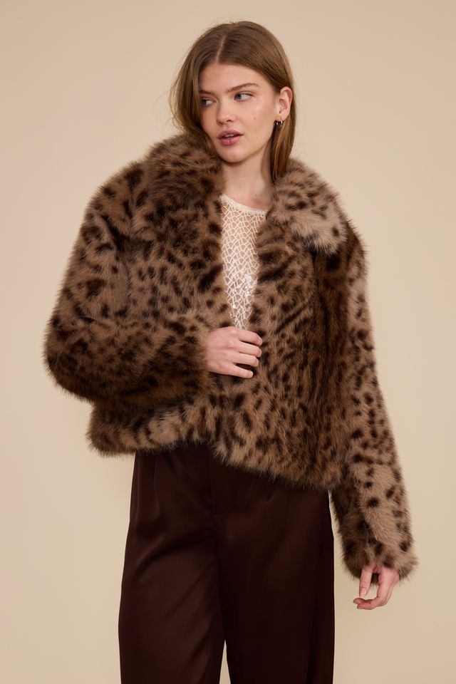 Model wearing cropped brown leopard faux fur jacket with burgundy trousers front view