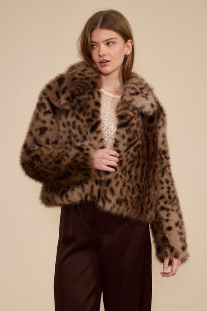 Model wearing cropped brown leopard faux fur jacket with burgundy trousers front view