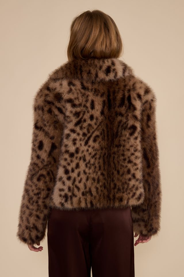 Back view of brown leopard print faux fur jacket on model with burgundy trousers
